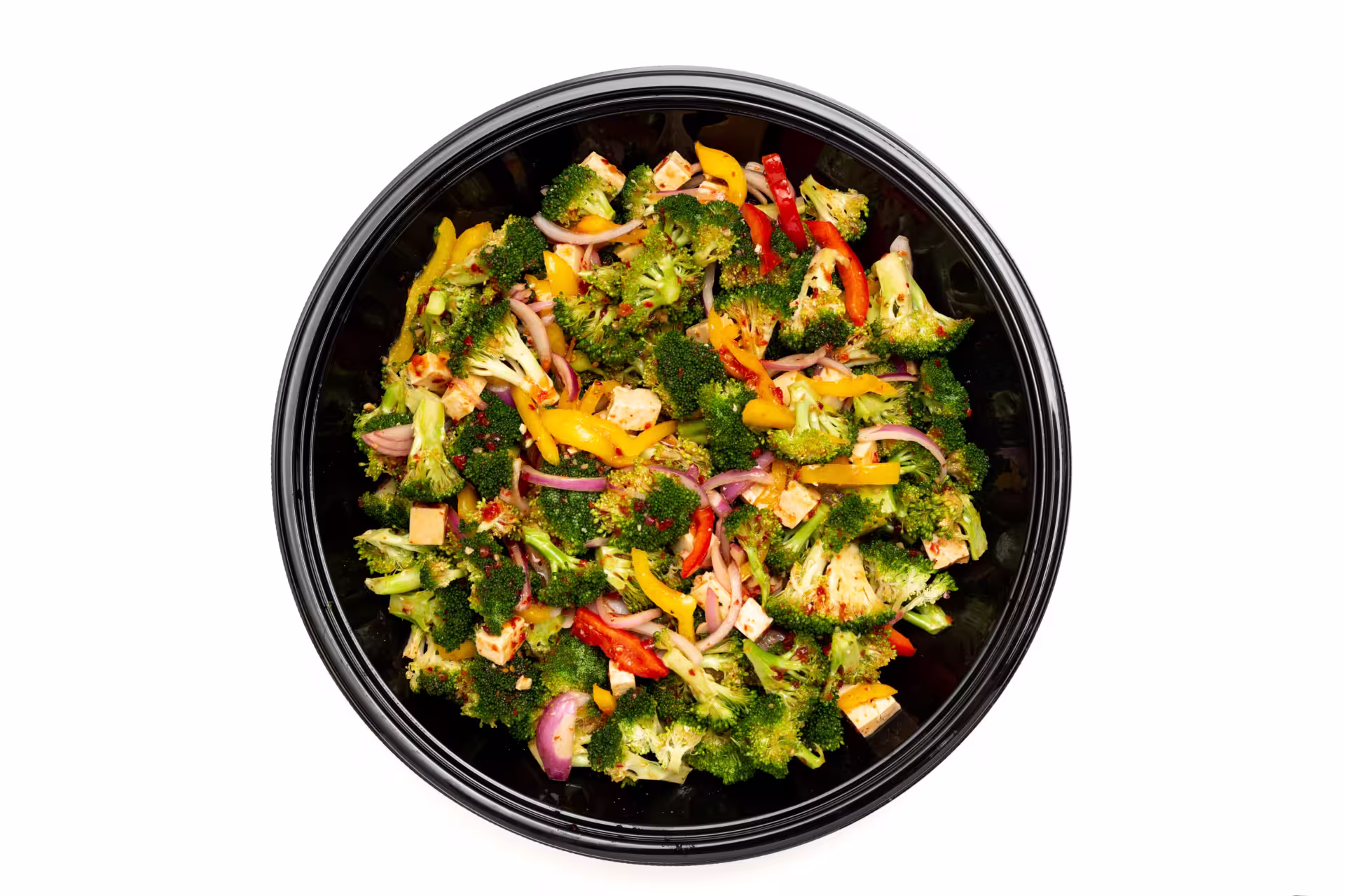 Large Broccoli salad with red, yellow bell pepper, red onion and sweet chili tofu dressing in a round take out container. Placed in a white background.