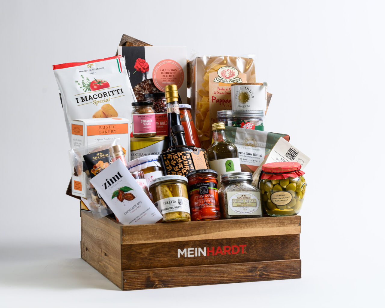 Gift basket of wooden crate with dark stain with Meinhardt written on it, containing about 27 food snacks, treats and 2 drinks