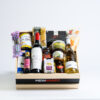 Snacks and Treats packed in a wooden crate with two wines in the front. The wooden crate is faded Beige color with a black strip and has Meinhardt written on it.