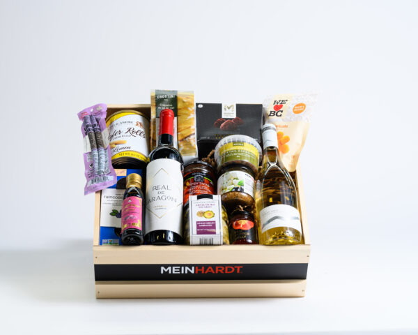 Snacks and Treats packed in a wooden crate with two wines in the front. The wooden crate is faded Beige color with a black strip and has Meinhardt written on it.
