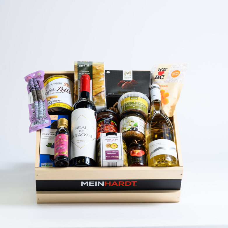 Snacks and treats packed in a wooden crate with two wines in the front.