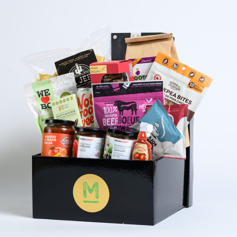 Local within BC snacks with different colored packages placed in an intricate arrangement in a Meinhardt black gift box.