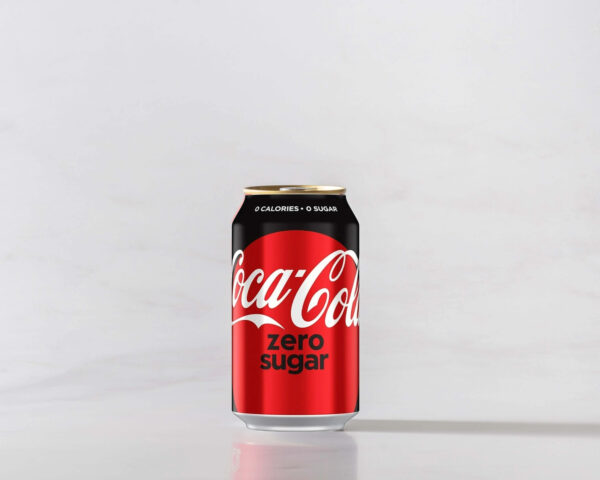 A can of Zero Coke original on a table with a shadow to the right. Theme white marble.
