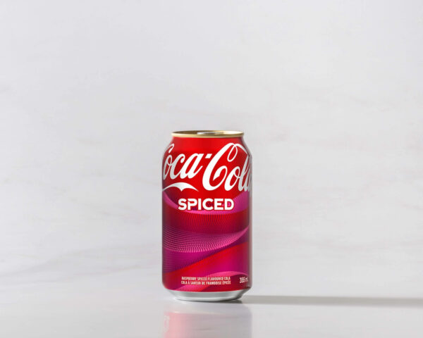 A can of Spiced Coke original on a table with a shadow to the right. Theme white marble.