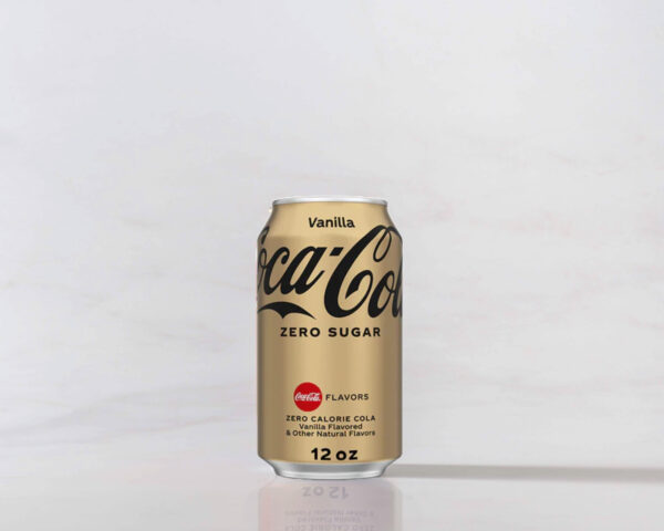 A can of Vanilla Coke Zero on a table with a shadow to the right. Theme white marble.